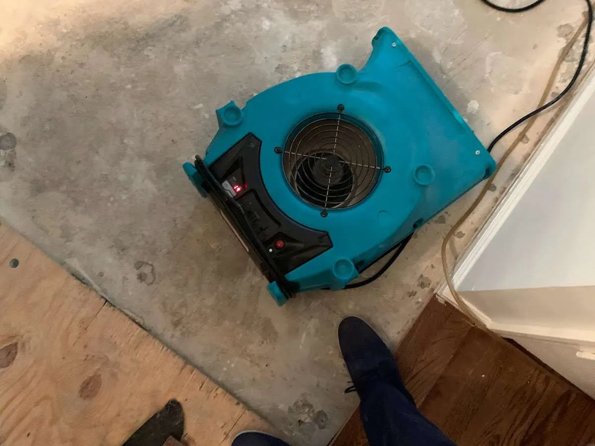 Air mover drying subfloor during Leak Detection & Repair in Salina